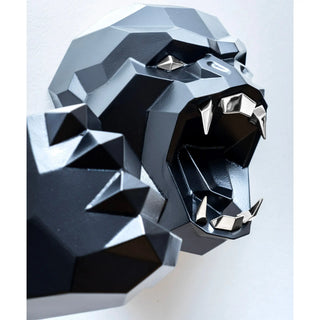 Sculpture murale d'une tête de gorille en métal avec ses deux bras qui sortent du mur fabriquée par l'artiste Cyril Maire, cette sculpture est peinte en noir et les yeux et les dents du gorille sont en inox brillant