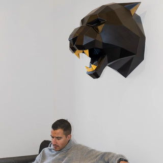 Sculpture d'une tête de tigre fabriquée en acier par l'artiste Cyril Maire, cette tête de tigre est peinte en noir et les dents en dorées.