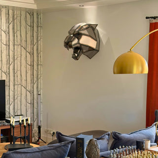 Une sculpture d'une tête de tigre en acier fixée sur un mur